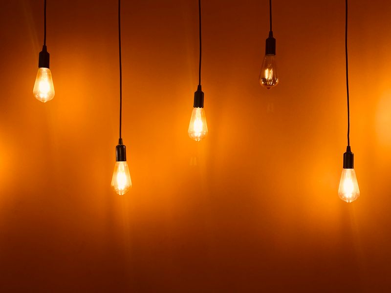 Warm Edison-style bulbs glowing against an amber background — the entry tier of color-faithful light.