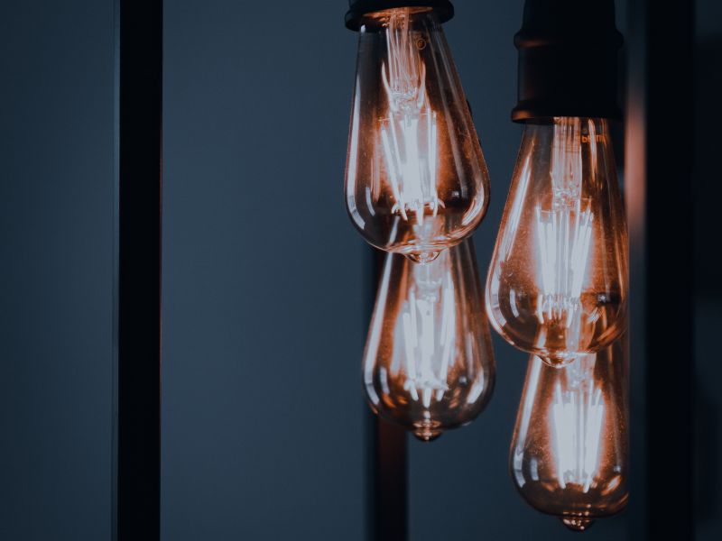Vintage Edison bulbs hanging in a dark warm interior — the mid tier where color rendering becomes reference-grade.
