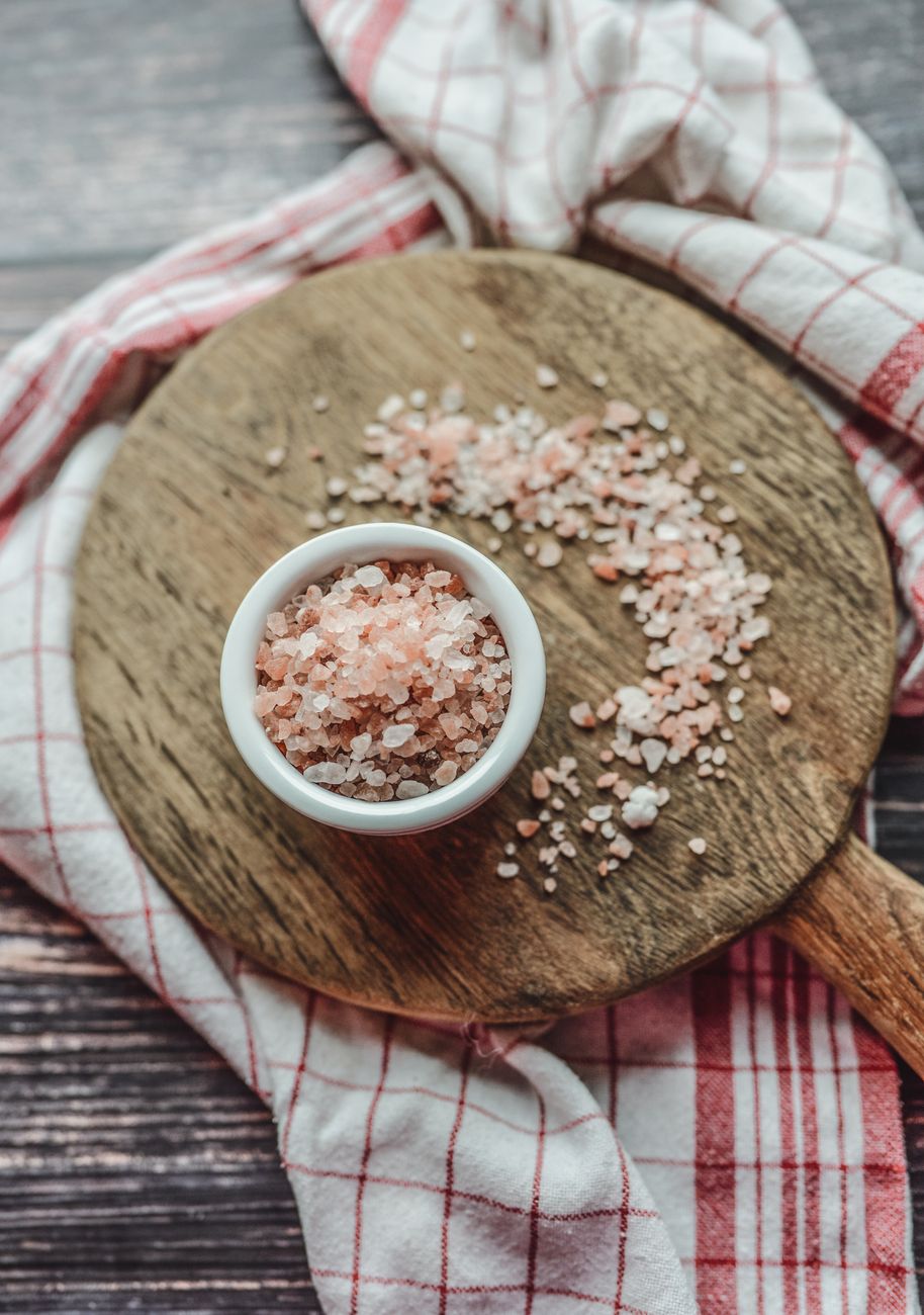 A wooden board with a bowl of Himalayan salt in warm morning light — the kind of surface an heirloom board sits on the counter as.